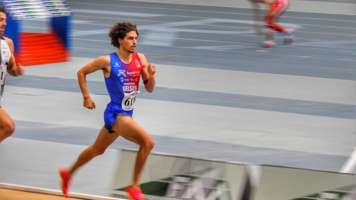 Rafael Moreno Burgos corriendo en una pista cubierta durante una carrera de medio fondo